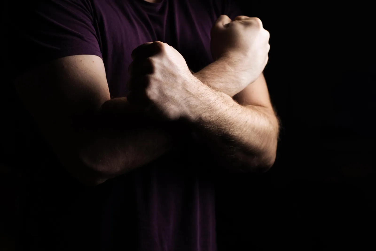 Close-up of a man&rsquo;s crossed forearms