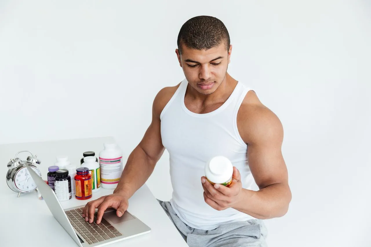 Man reviewing supplement information at a laptop